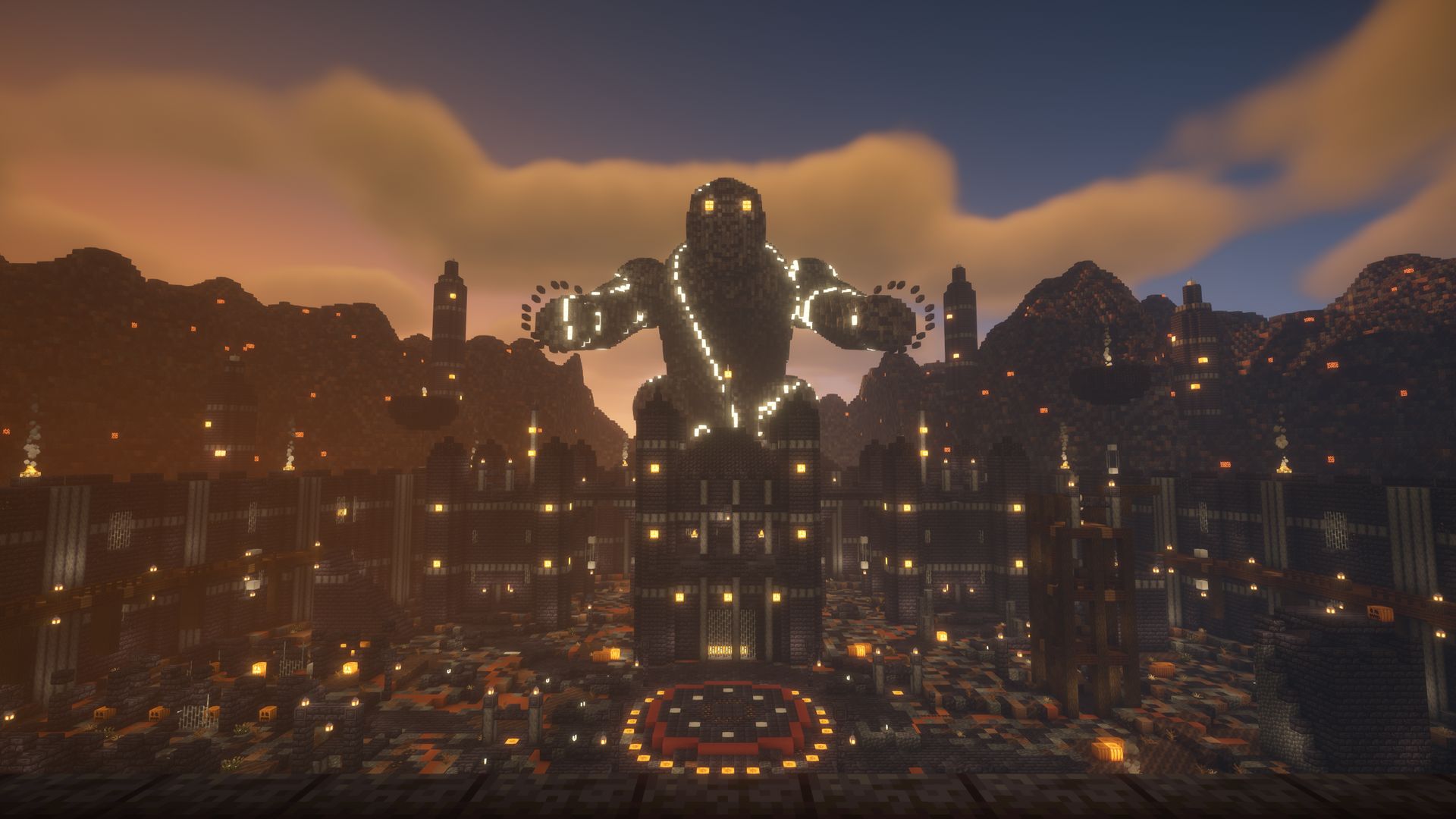 A walled arena town at sunset with a giant lit statue above the ring
